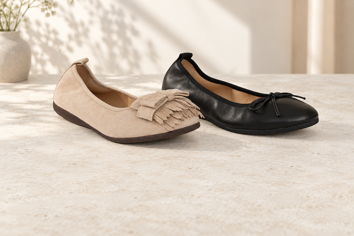 Beige CAMBIO Ballerina aus Veloursleder und schwarze BASIC Ballerina aus Nappaleder auf hellem Stein.